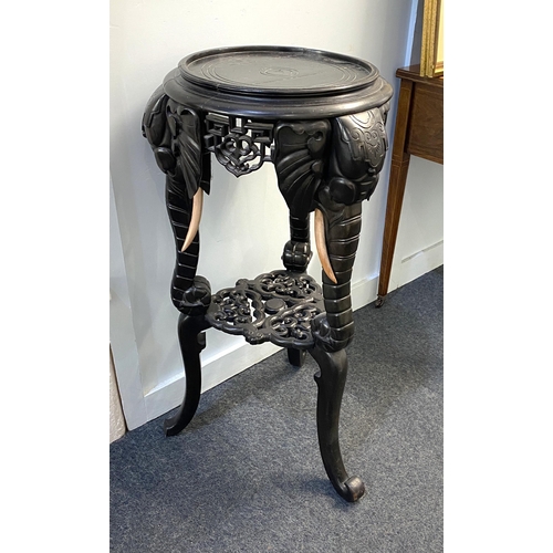 429 - An Anglo-Indian ebonised side table / jardiniere stand with circular top on tripod legs carved with ... 