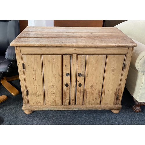 921 - An old pine plank cupboard with two panel doors enclosing shelf, on bun feet, height 72cm, width 97c... 