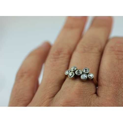 A gold and diamond ring collet set with seven old cut diamonds detailed ...