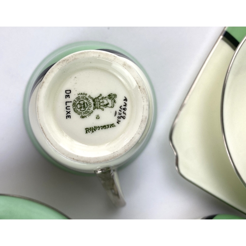 9 - An Art Deco Royal Doulton 'De Luxe' pattern part tea service in white and green, with silver and bla... 