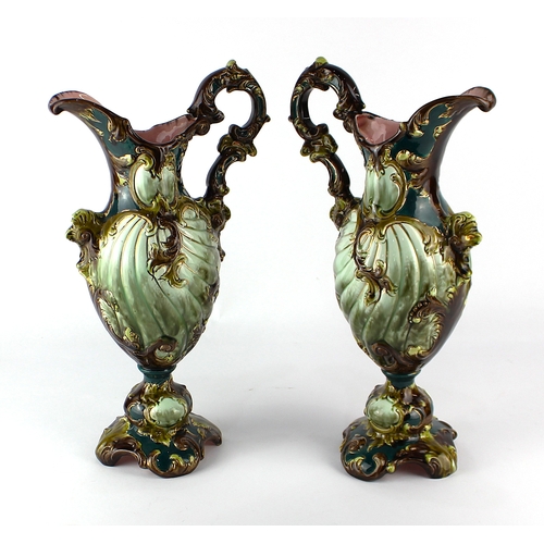 A pair of Austrian ceramic ewers of scrolling design with gilt, green ...