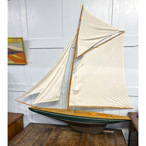 159 - A wooden built model yacht with canvas sails, 145cm high by 142cm long.