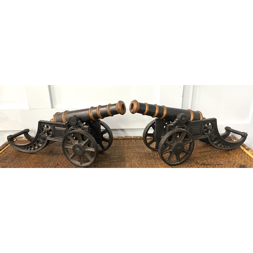 175 - A pair of cast iron models of cannons, 47cm long by 22cm high.