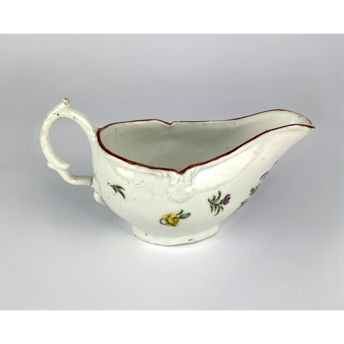 490 - An 18th century porcelain cream boat, probably Bristol, polychrome painted with floral sprays, red p... 