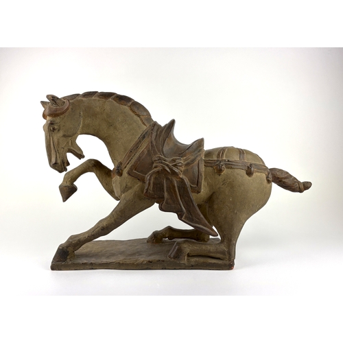 115 - A Chinese ceramic model of a prancing horse, after the Tang Dynasty style, well modelled and with at... 