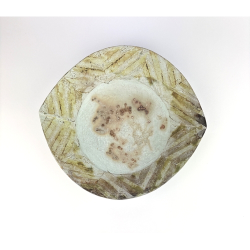 18 - Jane Perryman (b 1947), a smoke fired porcelain and T-material dish with striped decoration, incised... 