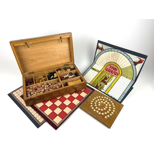 A cased wooden games compendium including chess pieces, draughts ...