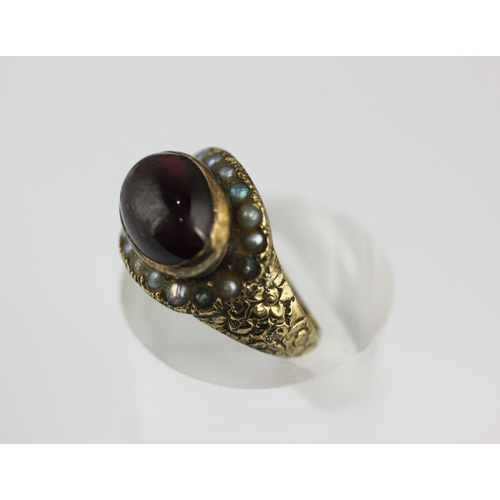 125 - A Victorian carbuncle garnet and seed pearl oval ring size M and a half, unmarked, loaded with trace... 