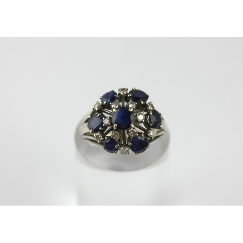 132 - A sapphire and diamond cluster ring, claw set with the principal circular cut sapphire at the centre... 