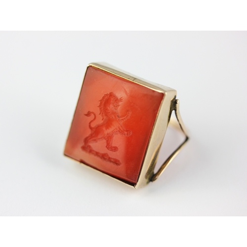 144 - A gold and cornelian intaglio ring the rectangular cornelian intaglio engraved with a lion crest, un... 