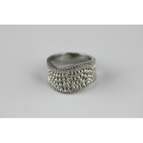 153 - An 18ct white gold ring in a dimpled abstract design mounted with rows of circular cut diamonds to t... 