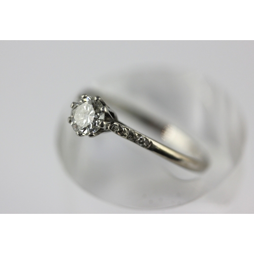 176 - A diamond ring claw set with the principal circular cut diamond at the centre, between diamond three... 