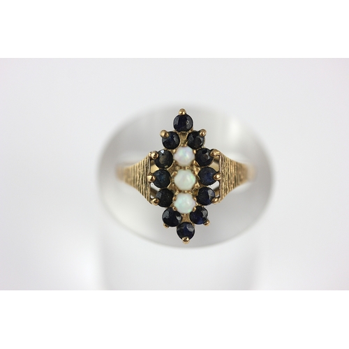 18 - A 9ct gold opal and sapphire marquise shaped cluster ring, set with three opals and with a surround ... 