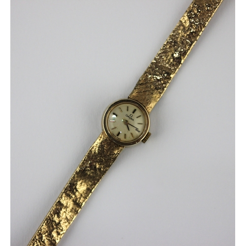 2 - An Omega 9ct gold lady's bracelet wristwatch having bark textured decoration to the bracelet, length... 
