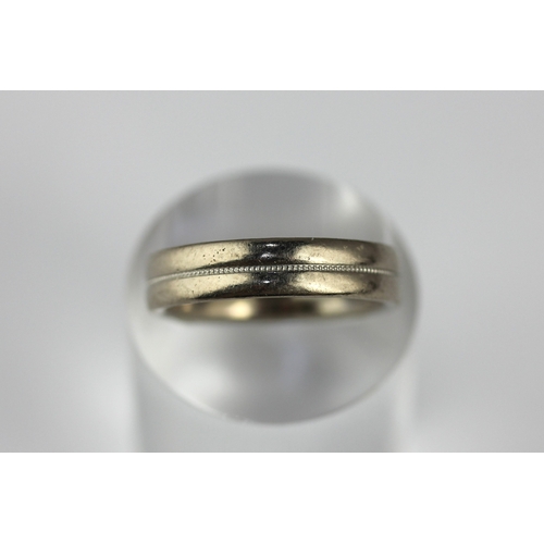 20 - An 18ct white gold wedding ring decorated with a central band, size O, gross weight 7.3g
 ... 