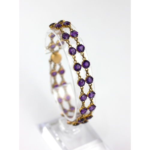 25 - A gold and amethyst bracelet claw set with two rows of circular cut amethysts on a snap clasp detail... 