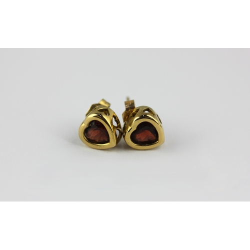 27 - A pair of gold and garnet single stone ear studs in a heart shaped design the backs with post and go... 