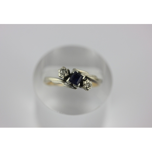 32 - A gold and platinum, sapphire and diamond three stone ring mounted with a rectangular cut sapphire b... 