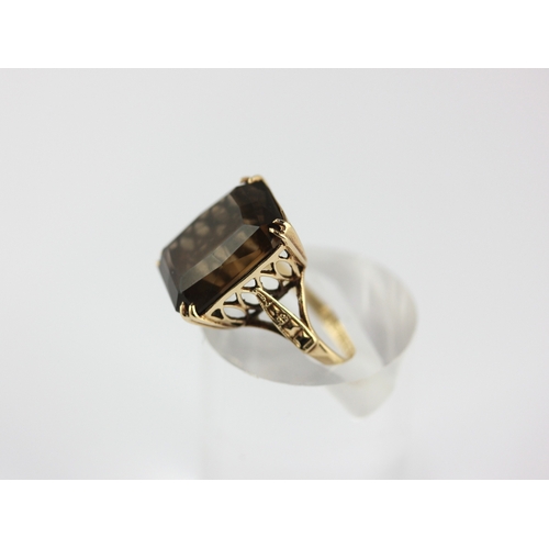44 - A 9ct gold ring claw set with a cut corned rectangular smoky quartz ring size K and half, gross weig... 
