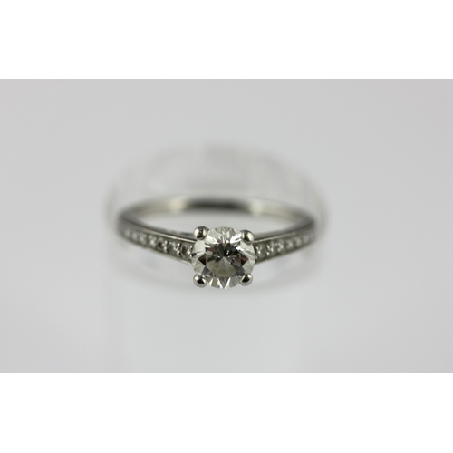 45 - A platinum and diamond ring claw set with a principal circular cut diamond at the centre, between ta... 
