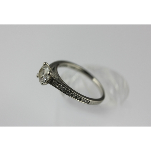 45 - A platinum and diamond ring claw set with a principal circular cut diamond at the centre, between ta... 