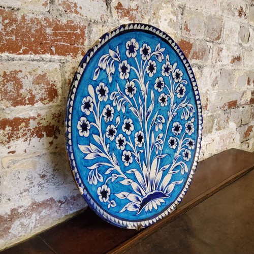 4 - An impressive large Persian Isnik pottery charger, tin glazed in turqouise and cobalt blue floral mo... 