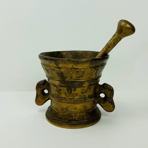 176 - A solid bronze pestle and mortar, decorated with coat of arms, 12cm diameter x 11cm high