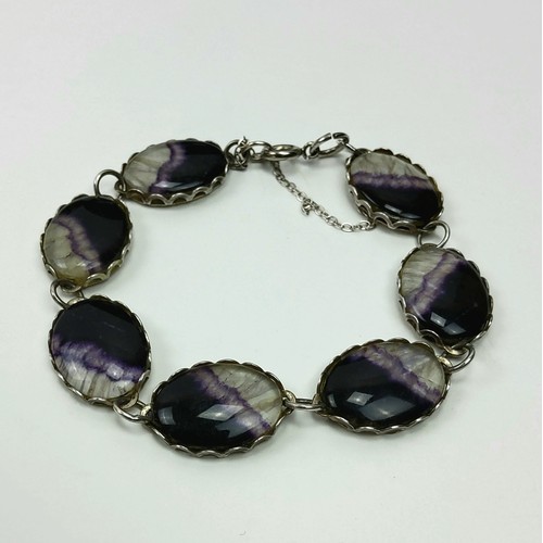 189 - A silver and Blue John bracelet, the alternating vibrant polished stone sections housed in silver ca... 