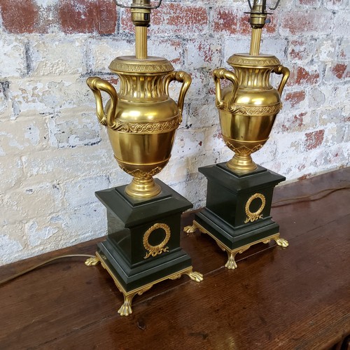 195 - A handsome pair of large twin handled urnular parcel gilt and Belgian black marble table lamps raise... 