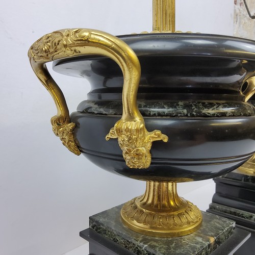 196 - A bold pair of Empire style gilt metal mounted marble table lamps, squatted twin handled urnular bod... 