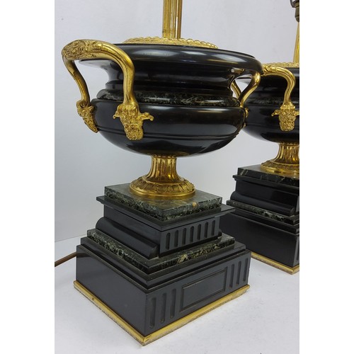 196 - A bold pair of Empire style gilt metal mounted marble table lamps, squatted twin handled urnular bod... 