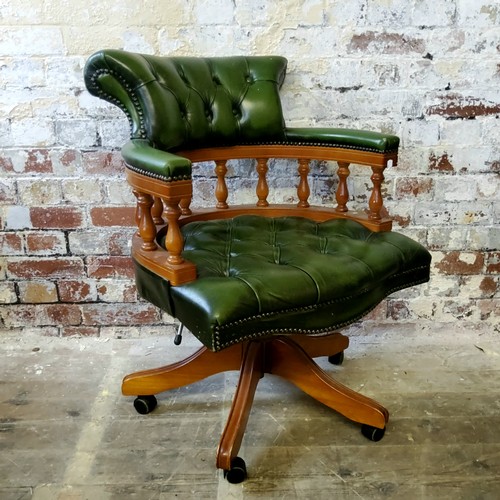 217 - A green leather button-backed swivel chair