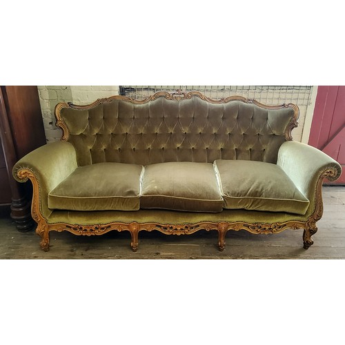 222 - A Louis XV style button back three seater sofa, the heavily carved serpentine frame profusely decora... 