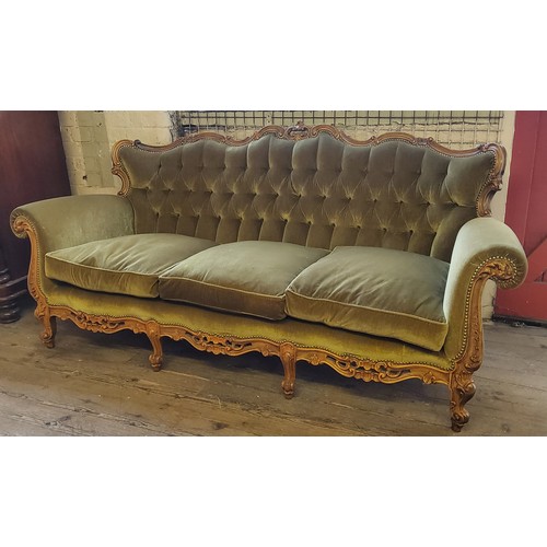 222 - A Louis XV style button back three seater sofa, the heavily carved serpentine frame profusely decora... 