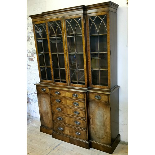 226 - A Regency Revival flamed mahogany breakfront library bookcase, oversailing cornice above three glaze... 