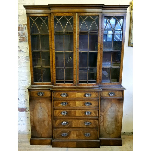 226 - A Regency Revival flamed mahogany breakfront library bookcase, oversailing cornice above three glaze... 