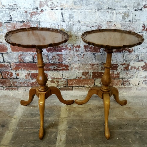 235 - A pair of mahogany shaped dished top wine tables raised on a baluster support on tripod legs termina... 