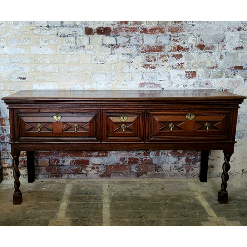243 - A Charles II oak dresser base, the rectangular two plank top over three geometrically moulded block ... 