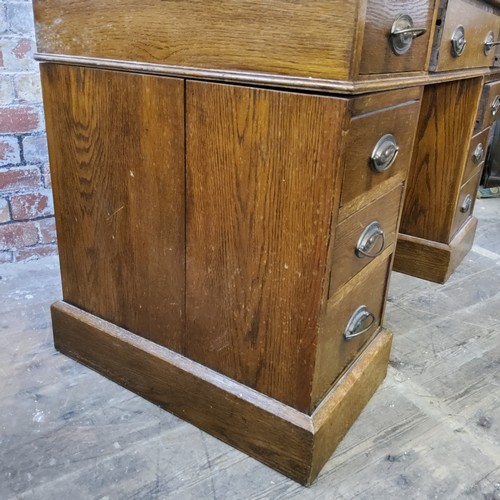 266 - An early 20th century oak knee hole pedestal desk, tooled leather inset surface above one long drawe... 