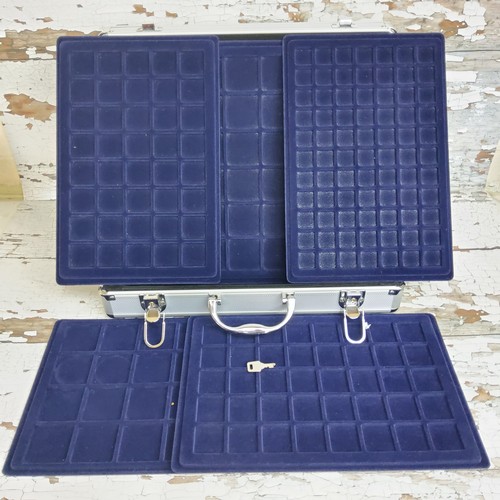 238 - A coin collectors carrying case, with multiple inset trays with varying coin size recesses, with key