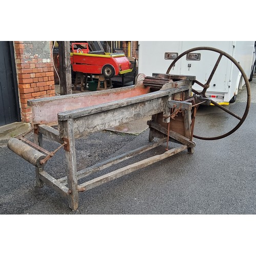 376 - A late Victorian/early 20th century corn threshing bench mounted with a substantial cast iron wheel ... 