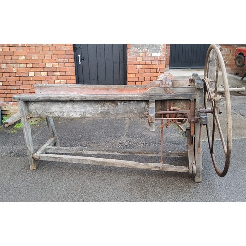 376 - A late Victorian/early 20th century corn threshing bench mounted with a substantial cast iron wheel ... 