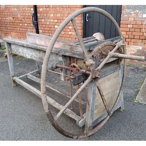 376 - A late Victorian/early 20th century corn threshing bench mounted with a substantial cast iron wheel ... 