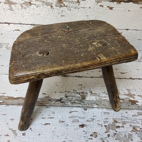 148 - An 18th century farmhouse elm three leg milking stool, well figured