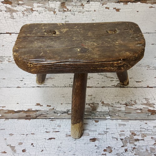 148 - An 18th century farmhouse elm three leg milking stool, well figured