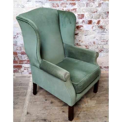 70 - A Georgian style wingback armchair, upholstered in sage green velvet