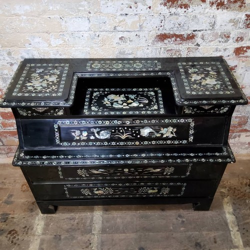 156 - An Asian black lacquered mother of pearl inlaid temple chest of drawers profusely inlaid throughout ... 