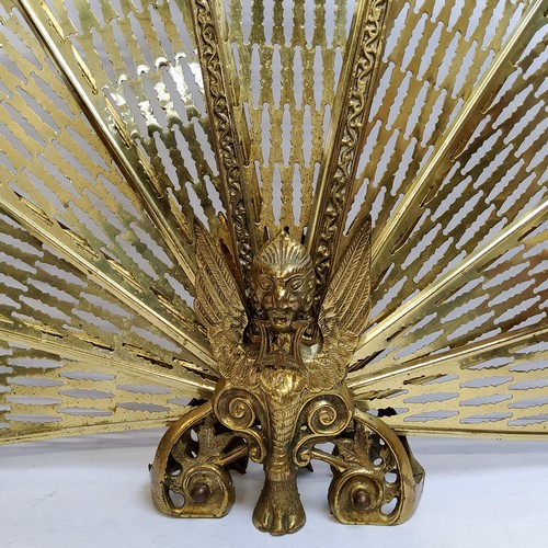 100 - A substantial early 20th century brass 'peacock' firescreen, with mythical Griffin and lion paw base... 