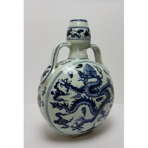 105 - A Chinese Ming style blue and white moon flask, decorated with imperial dragon amongst the clouds, w... 