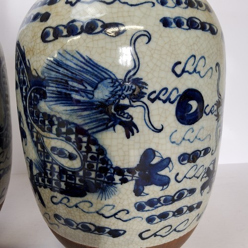 109 - A pair of large Chinese blue and white baluster vases decorated with dragons chasing the flaming pea... 